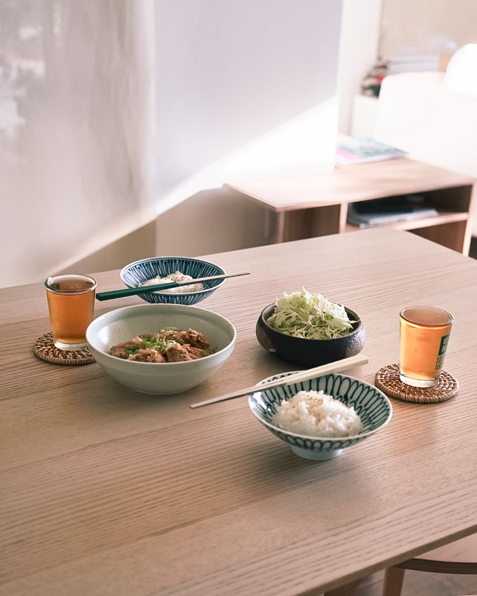 A dinner setting with  rice bowls, stainless steel chopsticks and Taiwanese beer cups. 