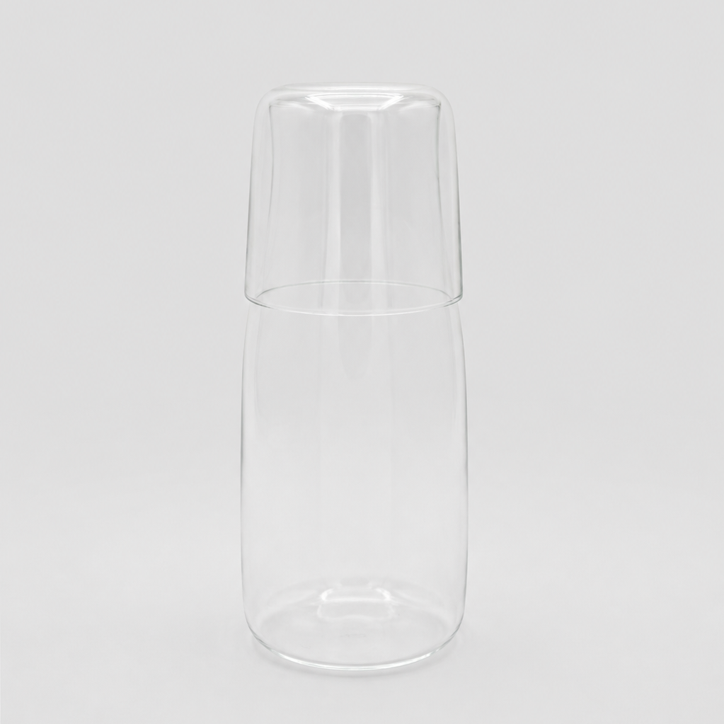Glass water carafe on a light grey background